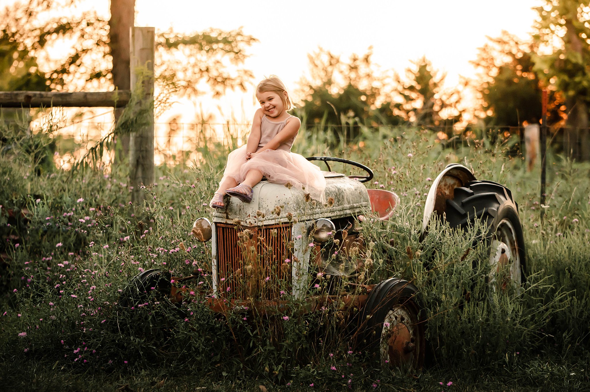 Little girl sitting on an old tractor in a dress Vintage Toy Store Cincinnati