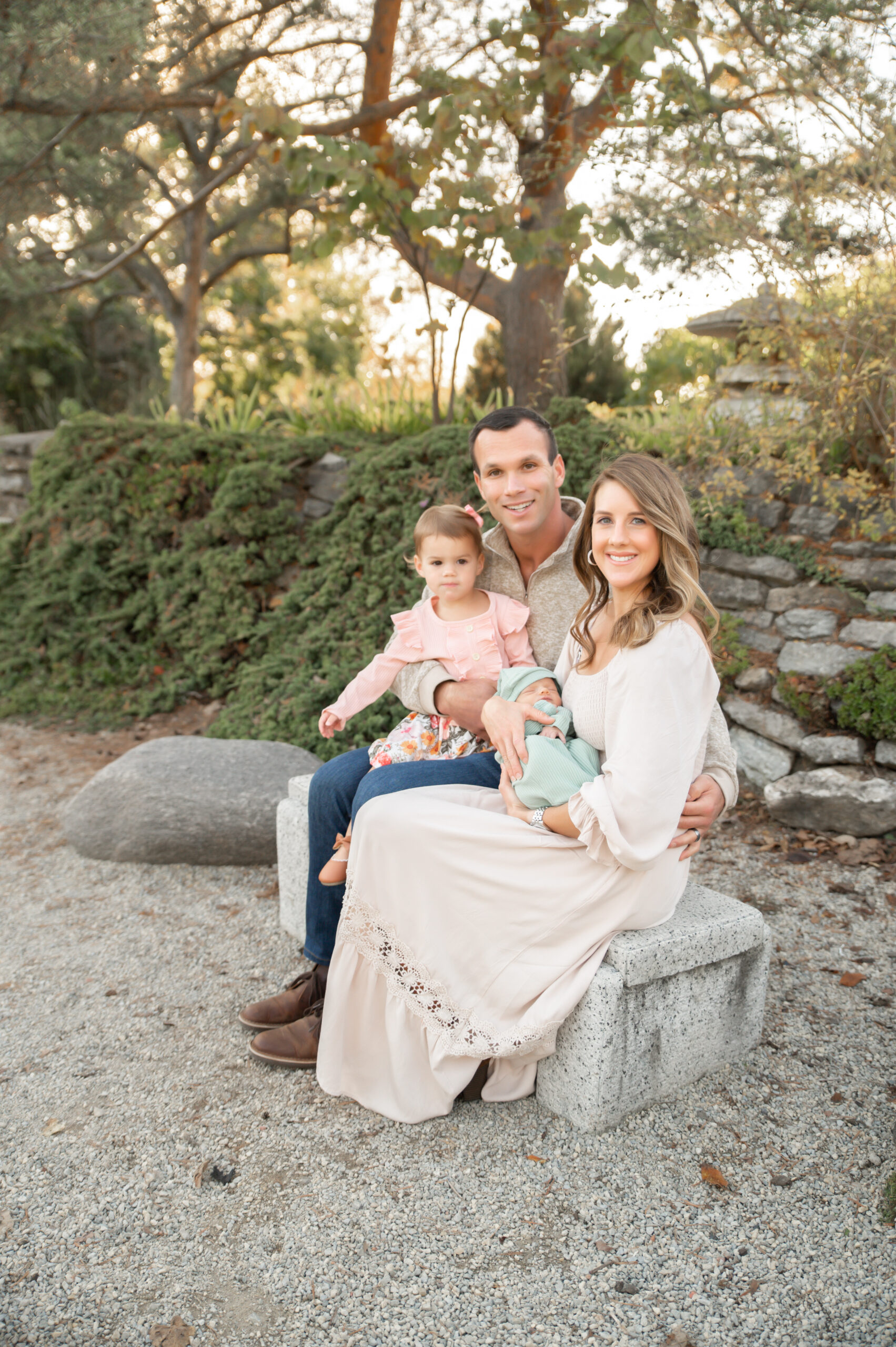 Family sitting in beautiful garden with newborn